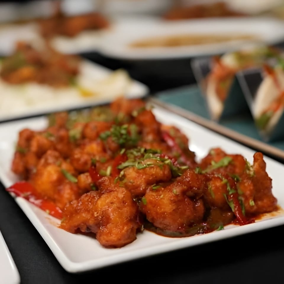 Chak De California's Indian Gobi Manchurian, a fried cauliflower dish, garnished with cilantro and peppers.
