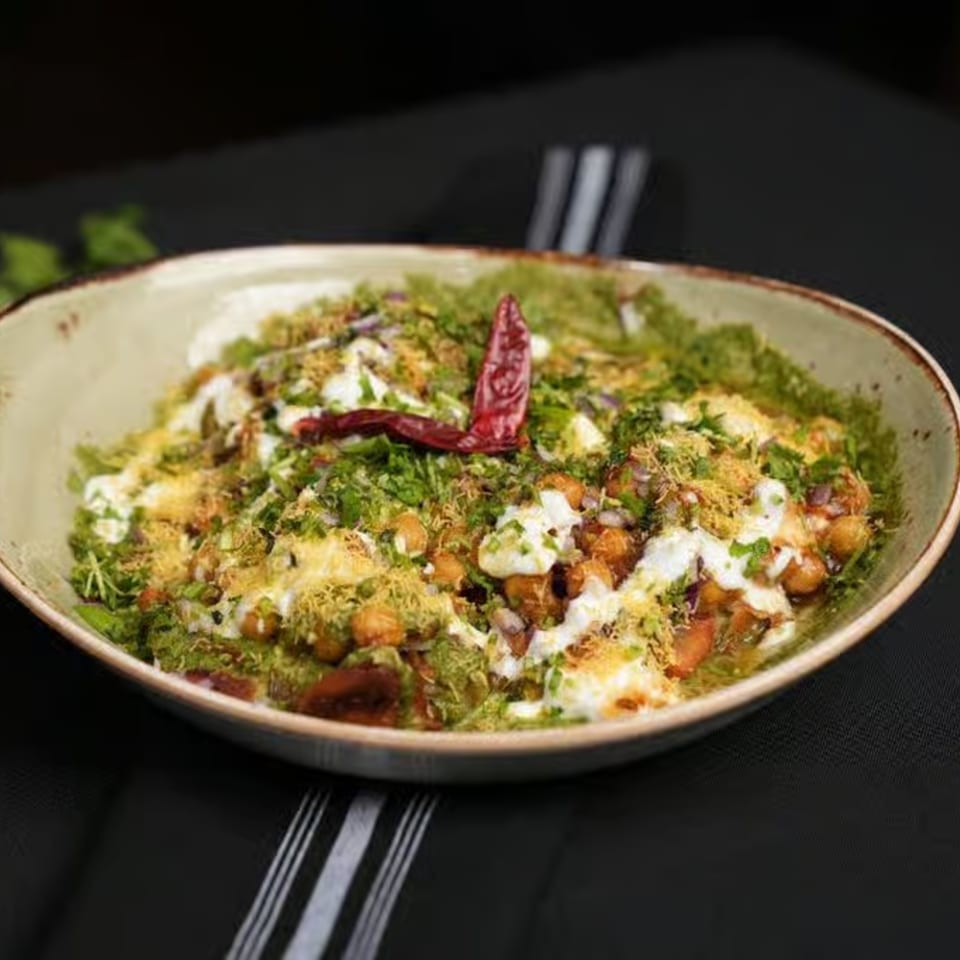 Chak De California's Indian chaat with chickpeas, green chutney, yogurt, and a red chili.