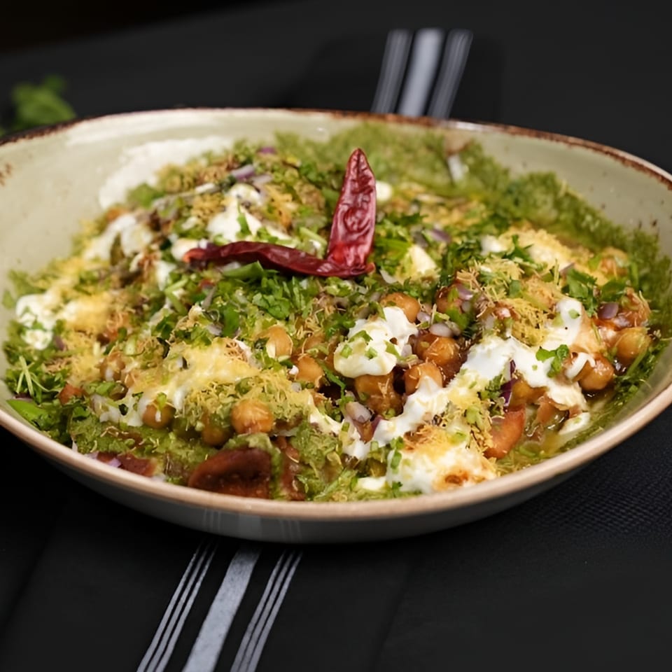 Chak De California's Indian chaat, topped with yogurt, green chutney, chickpeas, and a red chili.